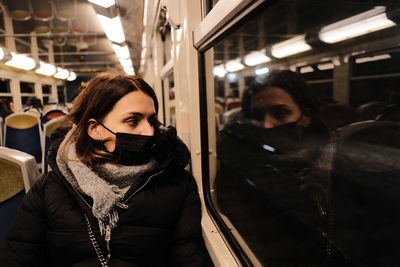 Rear view of woman standing in train