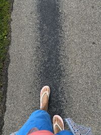 Low section of man standing on road