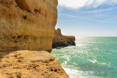 Rock formations by sea against sky