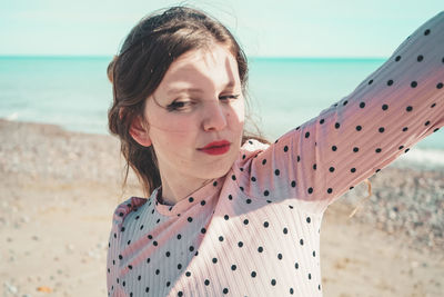 Woman looking down while standing on beach