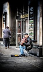 Man playing with umbrella on street in city