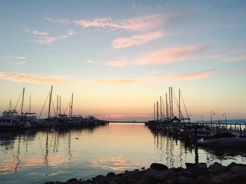 Boats moored in sea at sunset