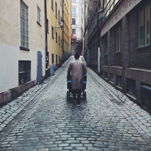 Rear view of man on cobblestone street