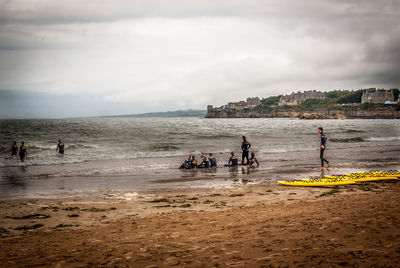 People on beach against sky