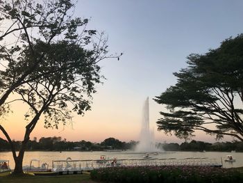 View of fountain at lake during sunset