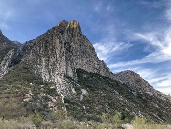 Low angle view of rocks on mountain against sky