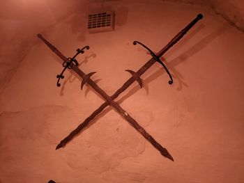 Low angle view of silhouette hanging against wall