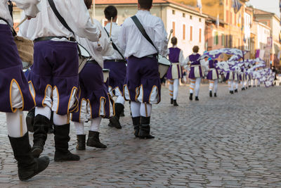 Rear view of people walking on street in city