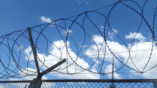 Low angle view of barbed wire against sky