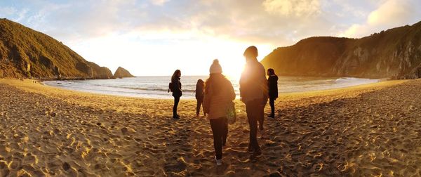 People on beach against sky