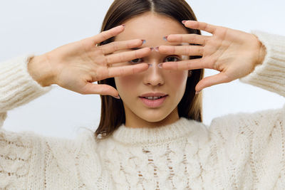 Portrait of young woman against white background