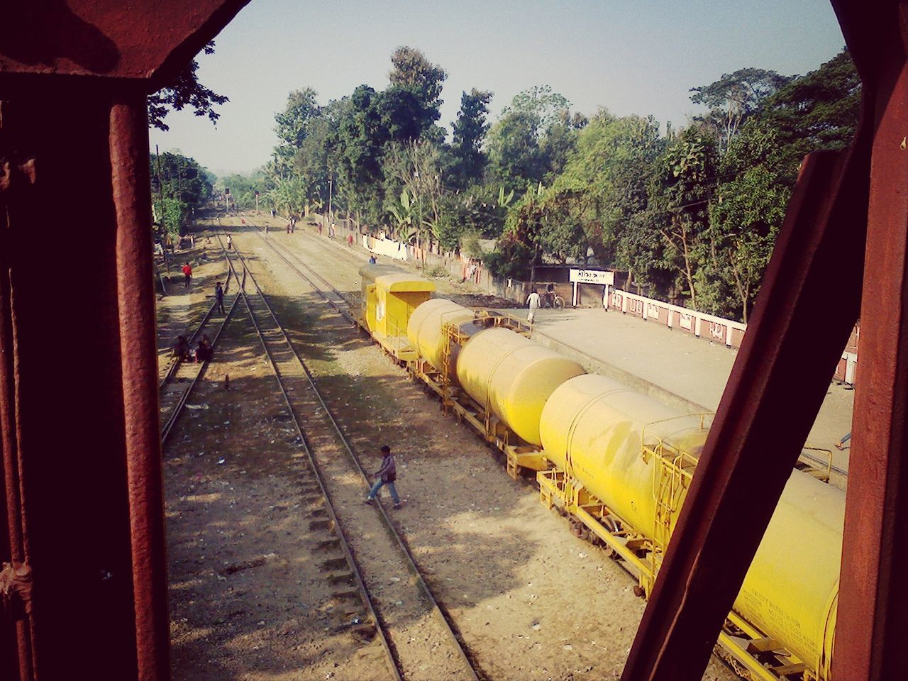 transportation, railroad track, tree, mode of transport, rail transportation, public transportation, railroad station platform, the way forward, land vehicle, train - vehicle, travel, car, railroad station, incidental people, diminishing perspective, road, built structure, day, street, train