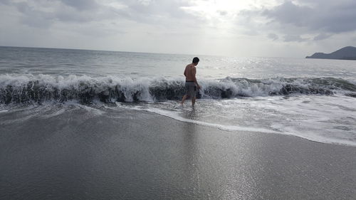 Man standing on beach against sky