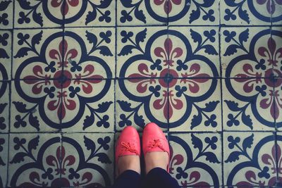 Low section of woman standing on floral pattern floor