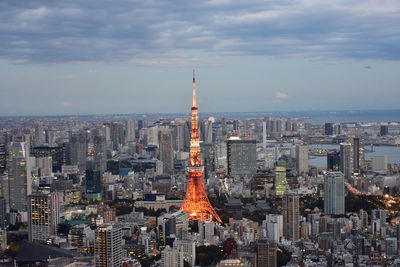 Aerial view of buildings in city against cloudy sky