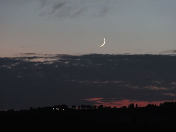 Low angle view of silhouette moon against sky at sunset