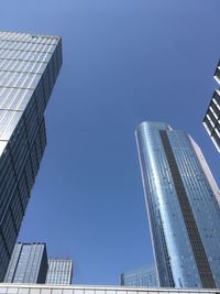 Low angle view of modern buildings against clear blue sky