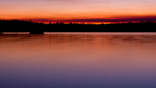 Scenic view of lake against romantic sky at sunset