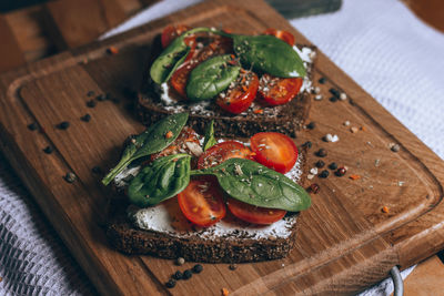 Sandwich with cream cheese, cherry tomatoes, spinach and spices. delicious healthy veggie food. 