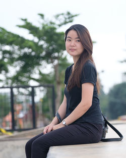 Portrait of smiling young woman sitting outdoors