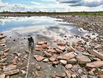 View of rocks in lake against sky