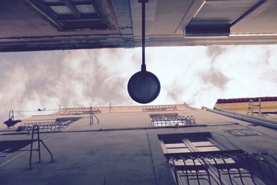 Directly above shot of street light amidst buildings against cloudy sky