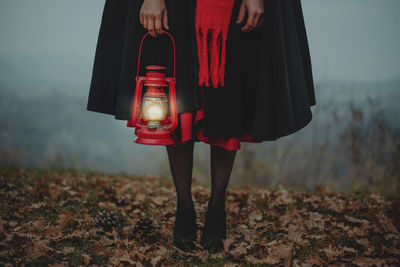 Low section of woman standing on field