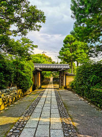 Footpath in park against sky