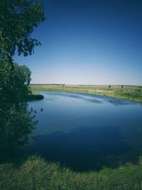 Scenic view of lake against clear blue sky