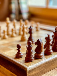 Old wooden chess board with focused tower, blurred background, vertical shot