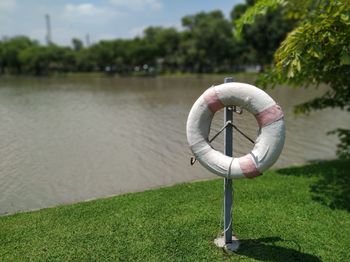 Coin-operated binoculars on grass by lake