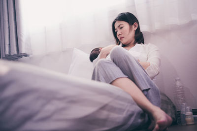 Mother with son lying on bed at home