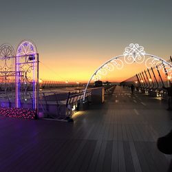 Illuminated ferris wheel against sky at night