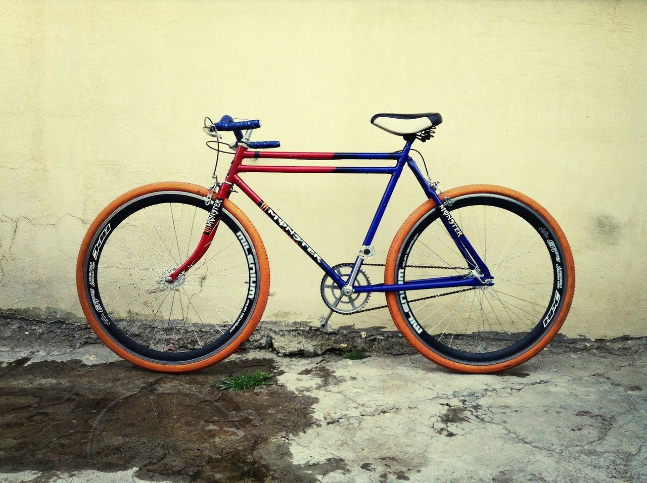 bicycle, wall - building feature, metal, transportation, stationary, wall, built structure, wheel, no people, close-up, day, outdoors, parking, parked, mode of transport, architecture, copy space, circle, rusty, clear sky