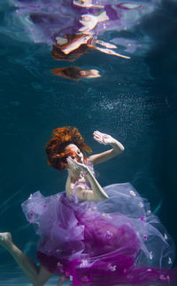 Woman with eyes closed swimming in pool