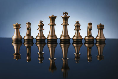 Close-up of chess pieces on table against colored background