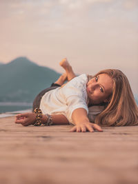 Portrait of woman lying down against sky