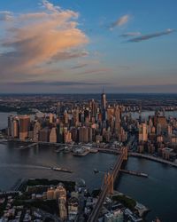 Scenic view of river by buildings against sky during sunset