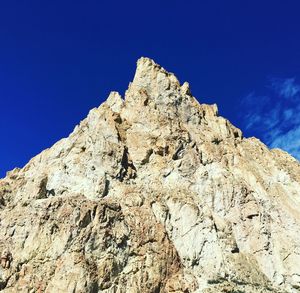 Low angle view of mountain against clear blue sky