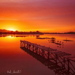 Pier on lake at sunset