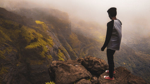 Rear view of man standing on mountain