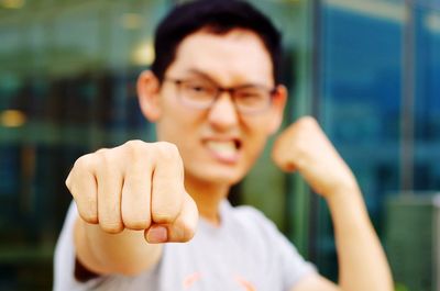 Close-up of young man punching in city