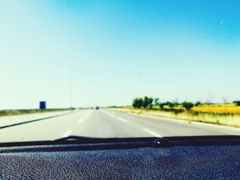Close-up of road against clear blue sky