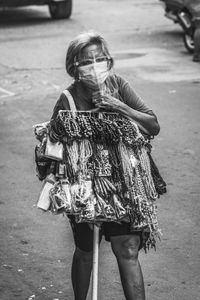 Full length of woman with umbrella standing on street