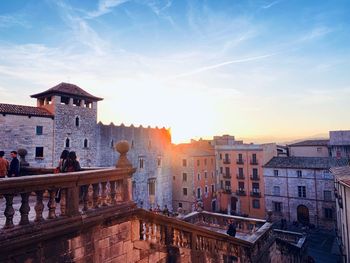 Buildings in city against sky during sunset