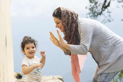 Side view of mother carrying daughter