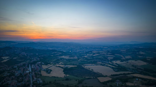 Aerial view of cityscape against sky during sunset