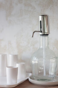 Close-up of wineglass on table against wall at home