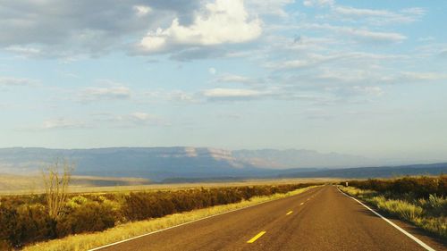 Road by landscape against sky