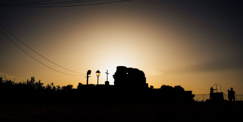 Silhouette people against clear sky during sunset